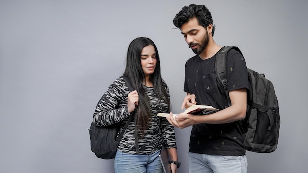 dois alunos usando óculos e de mãos dadas usando laptop modelo indiano do Paquistão