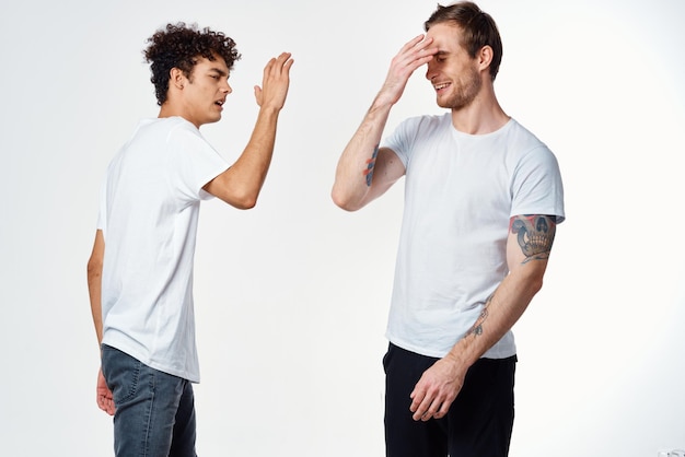 Dois amigos alegres em camisetas brancas alegria Fundo de luz positiva Foto de alta qualidade