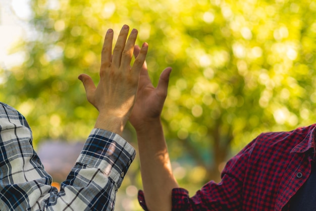 Dois amigos batem high five ao ar livre em um dia de verão