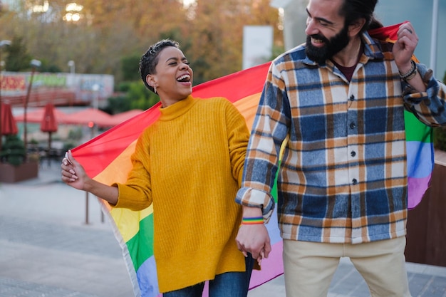 Dois amigos comemorando o dia do orgulho lgtbi com a bandeira do arco-íris Conceito orgulho símbolos direitos civis