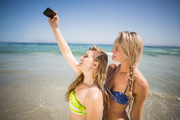 Dois amigos de biquíni tomando uma selfie