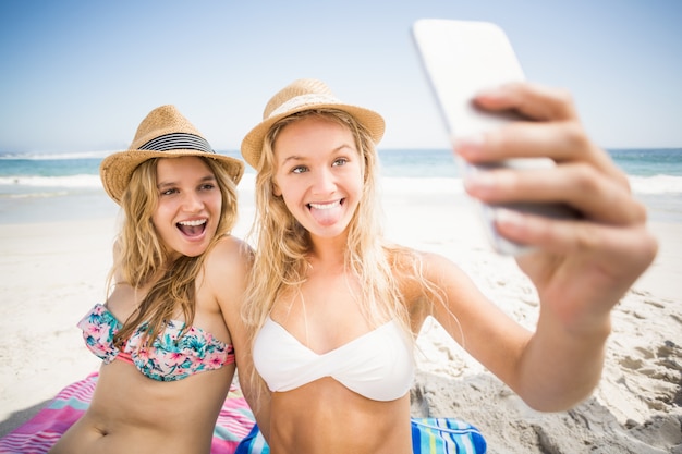 Dois amigos de biquíni tomando uma selfie