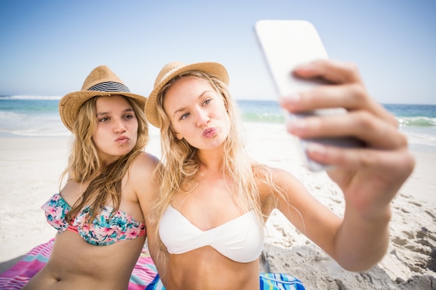 Dois amigos de biquíni tomando uma selfie