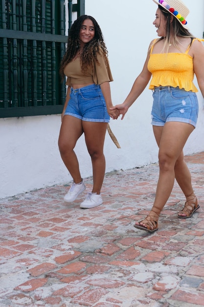 Dois amigos de mãos dadas na rua