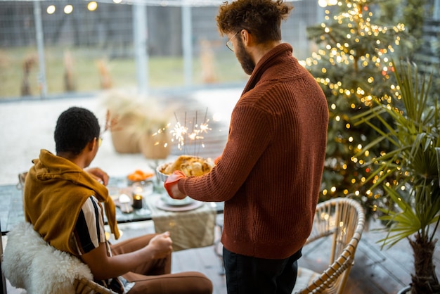 Dois amigos do sexo masculino jantando festivo no quintal