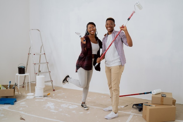 Dois amigos estão renovando o dormitório eles estão trabalhando juntos pintando paredes