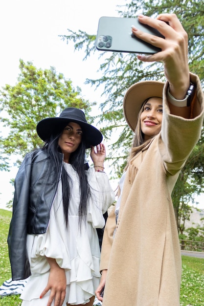 Dois amigos estilosos tirando uma selfie no parque