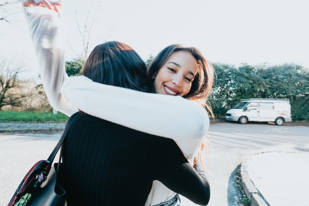 Dois amigos estudantes universitários se abraçando felizes depois de se encontrarem novamente no campus após as férias. Abraço lindo conceito. Estude e aprenda juntos o conceito. De volta à escola e às aulas.