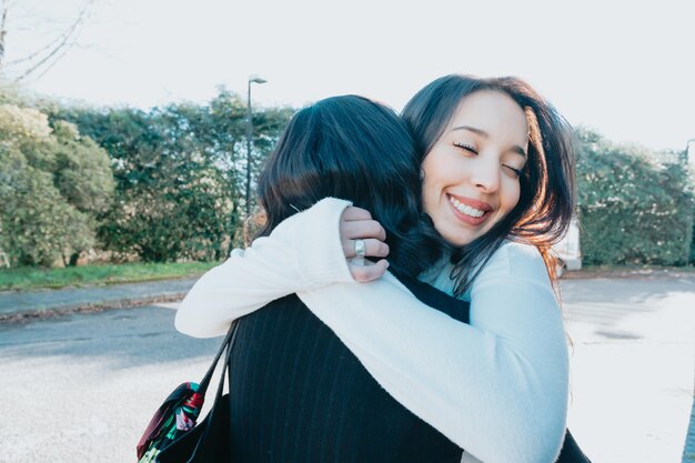 Dois amigos estudantes universitários se abraçando felizes depois de se encontrarem novamente no campus após as férias. Abraço lindo conceito. Estude e aprenda juntos o conceito. De volta à escola e às aulas.