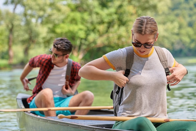 Dois amigos exploradores aventureiros estão praticando canoagem em um rio selvagem cercado pela bela natureza