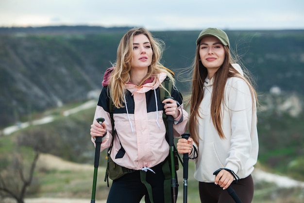 Dois amigos fazem uma caminhada fácil nas montanhas, belas senhoras descansam na natureza, amizade.