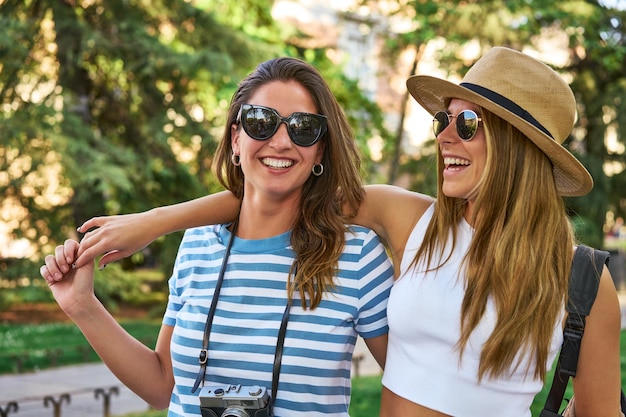 Dois amigos felizes em férias capturando memórias com uma câmera