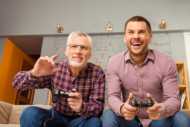 Dois amigos felizes jogando videogame em casa