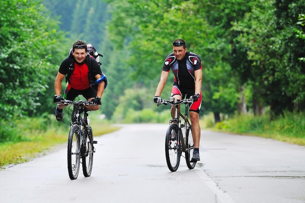 dois amigos se divertem ao ar livre na natureza e representando o conceito de vida saudável e fitness na mountain bike