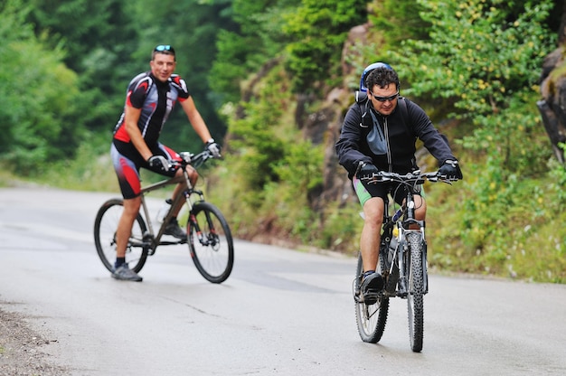 dois amigos se divertem ao ar livre na natureza e representando o conceito de vida saudável e fitness na mountain bike