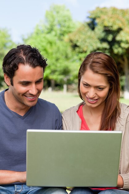 Dois amigos sorridentes enquanto observam algo em um comprimido