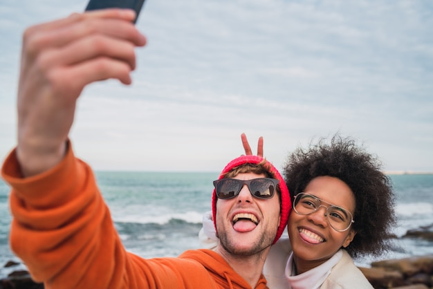 Foto dois amigos tomando uma selfie com smartpone.
