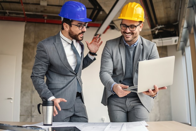 Dois arquitetos em processo de construção conversando e discutindo sobre inovações em seu projeto.