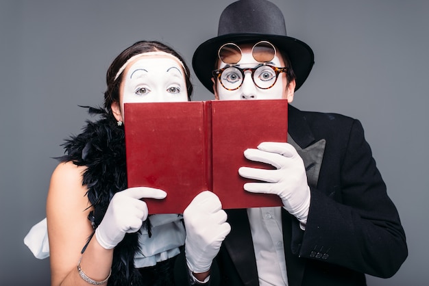 Dois artistas de comédia posando com o livro. Ator e atriz de teatro pantomima se apresentando