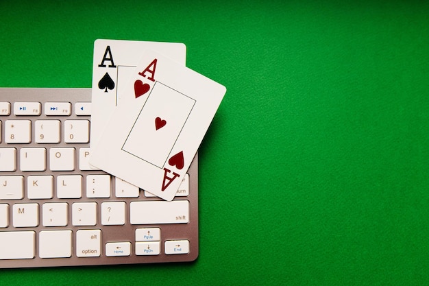 Dois ases e teclado branco em um fundo verde Conceito de poker online