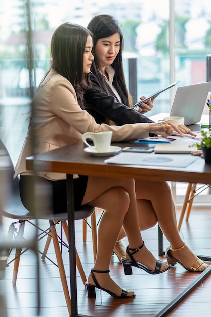 Dois asiáticos empresária com terno formal trabalhando e brainstorming juntamente com technolog