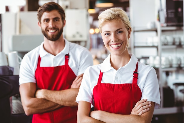 Dois baristas sorrindo para a câmera