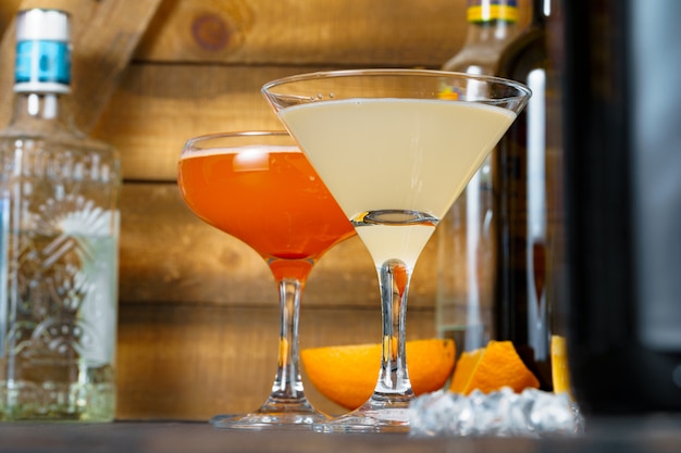 Dois belos cocktails servidos em um balcão de bar de madeira