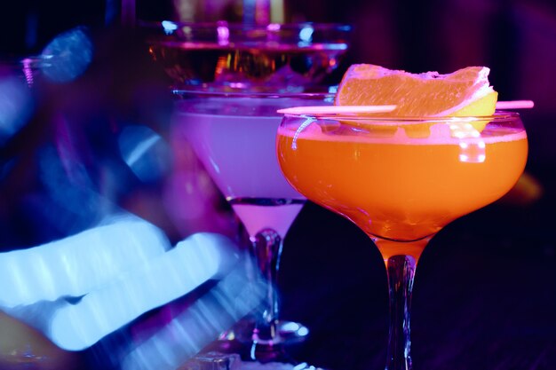 Dois belos cocktails servidos em um balcão de bar de madeira