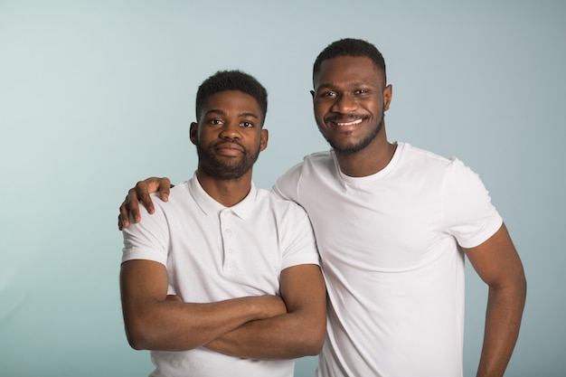 Foto dois belos homens africanos em camisetas brancas sobre fundo azul