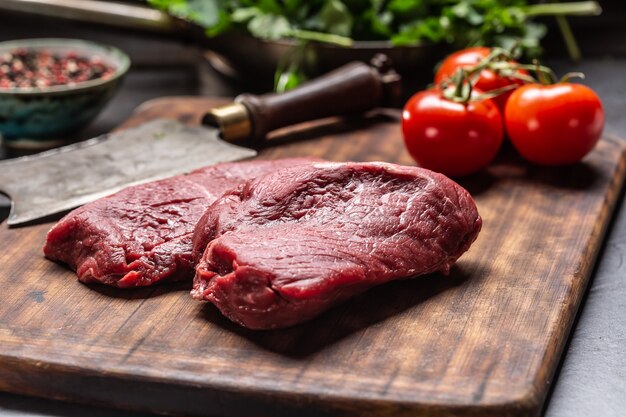 Dois bifes de alcatra com ervas, tomate, sal e especiarias no açougue.