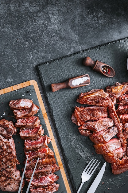 Dois bifes striploin e t-bon, mal passado, sobre um fundo de pedra. conceito de jantar para dois