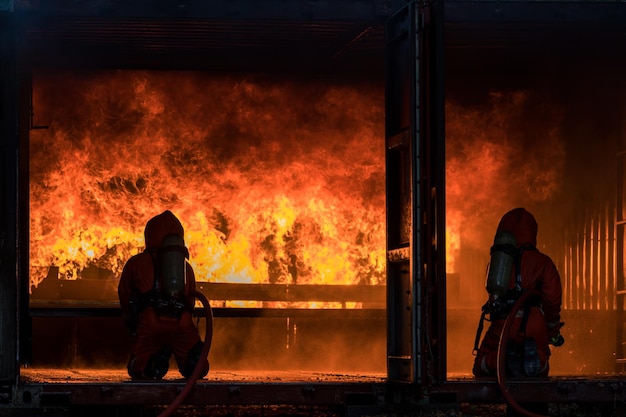 Dois bombeiros em frente a uma fogueira com as palavras fogo na parede