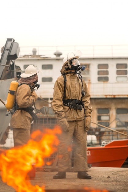 Foto dois bombeiros usam o trabalho em equipe em um treinamento para parar fogo em uma missão perigosa e proteger o meio ambiente