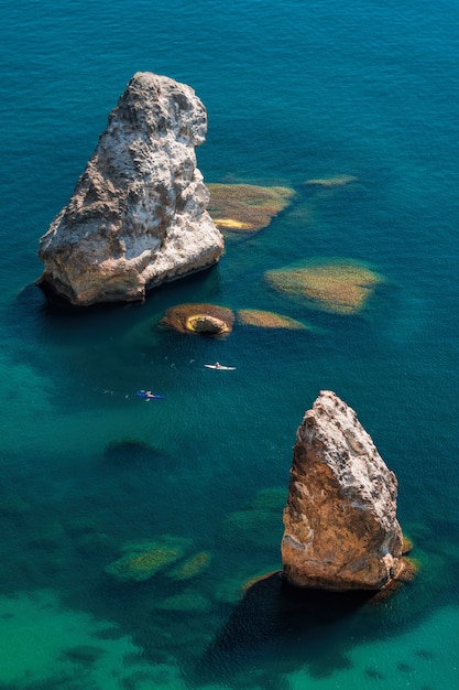 Dois caiaques no mar azul claro calmo, rocha orest e pilad, cabo fiolent em balaklava sevastopol crimeia. o conceito de uma vida ativa e saudável em harmonia com a natureza