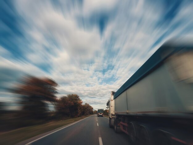 Foto dois caminhões estão dirigindo em uma rodovia vazia efeito de movimento desfocado