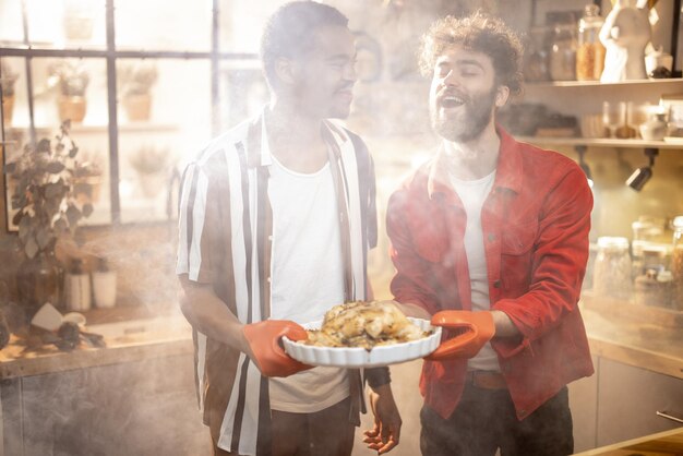 Dois caras com refeição cozida juntos na cozinha