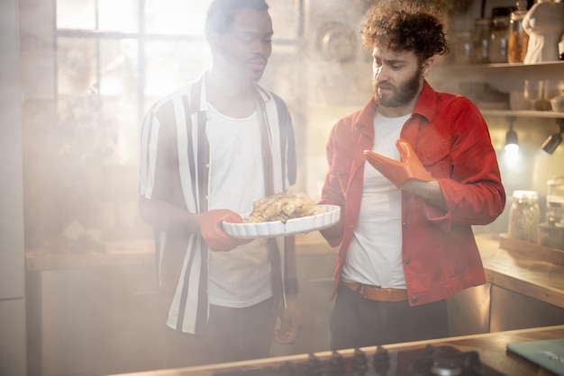 Dois caras com refeição cozida juntos na cozinha