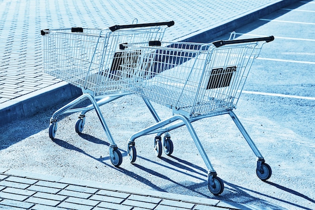 Foto dois carrinhos de compras vazios no estacionamento de uma loja