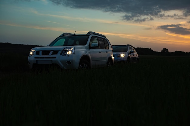 Dois carros SUV no pôr do sol. conceito de viagem por estrada. copie o espaço