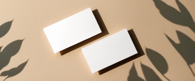 Dois cartões de visita brancos em branco em uma superfície bege perfeitos para modelos de marca