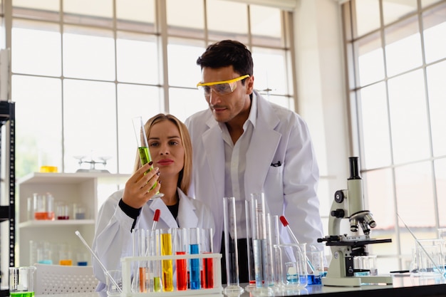 Dois, cientista, olhar, tubo vidro, enquanto, fazendo, pesquisa, em, laboratório ciência