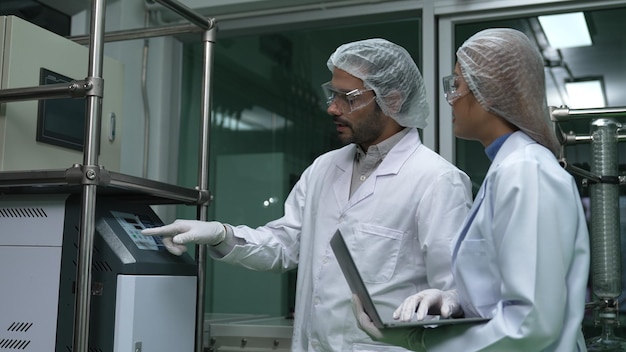 Dois cientistas de uniforme profissional trabalhando em laboratório para experimentos químicos e biomédicos