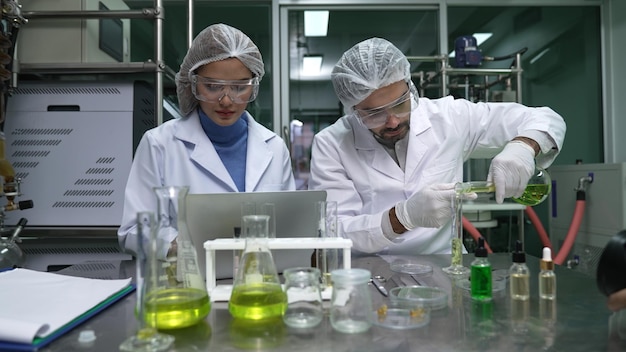 Dois cientistas em uniforme profissional a trabalhar no laboratório.