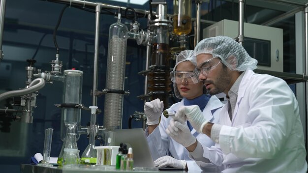 Dois cientistas em uniforme profissional trabalhando em laboratório para experiências químicas e biomédicas