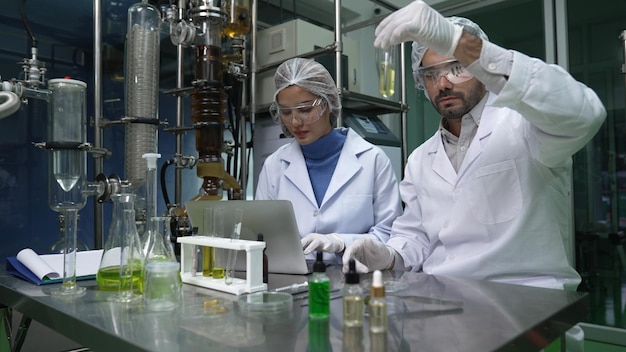 Dois cientistas em uniforme profissional trabalhando em laboratório para experimentos químicos e biomédicos