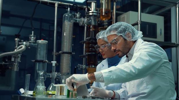 Dois cientistas em uniforme profissional trabalhando em laboratório para experimentos químicos e biomédicos