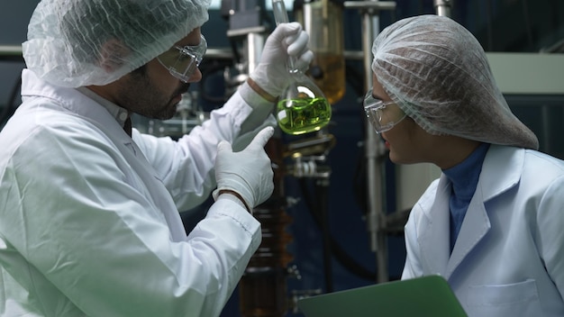 Dois cientistas em uniforme profissional trabalhando em laboratório