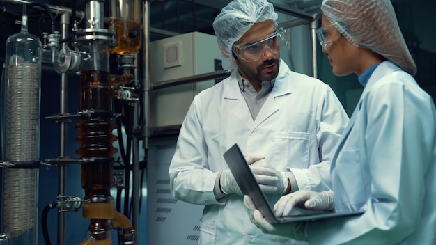 Dois cientistas em uniforme profissional trabalhando em laboratório