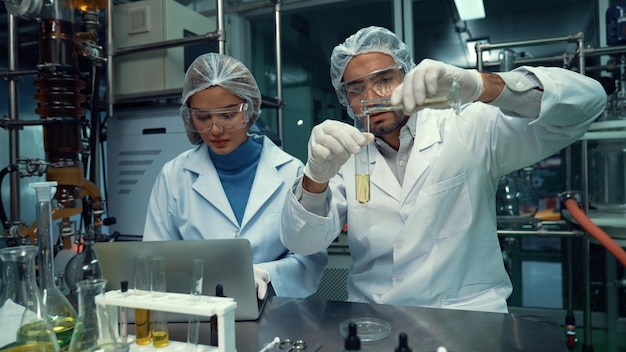 Dois cientistas em uniforme profissional trabalhando em laboratório