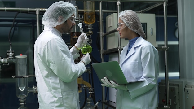 Dois cientistas em uniforme profissional trabalhando em laboratório